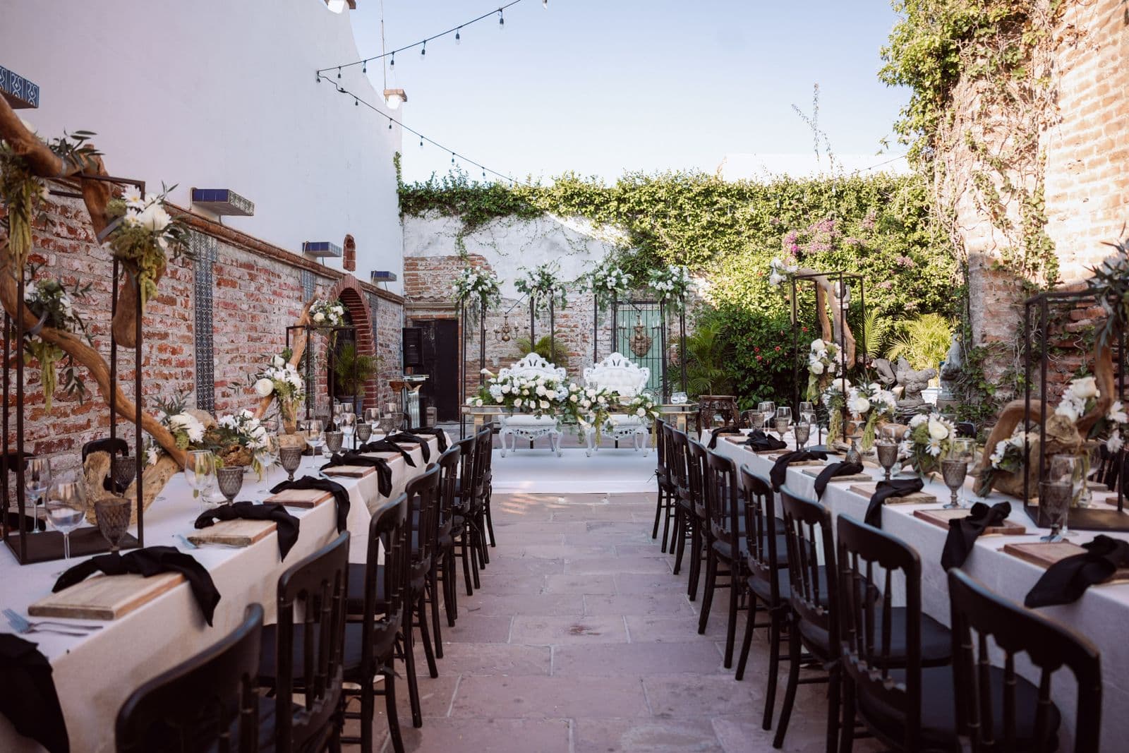 Réception de mariage en extérieur avec tables dressées, mobilier et guirlandes lumineuses installés par un loueur de matériel événementiel